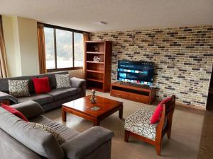 a living room with a couch and a television at Depar Rio Cuenca - Confortable in Cuenca