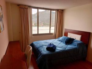 a bedroom with a bed and a large window at Depar Rio Cuenca - Confortable in Cuenca