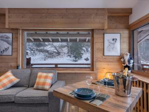 a living room with a couch and a table at CHALET " JEANE " proche centre in Megève