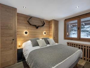 a bedroom with a large bed with a wooden wall at CHALET " JEANE " proche centre in Megève