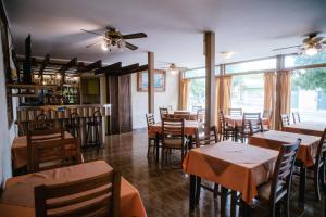 a restaurant with tables and chairs and a ceiling fan at Hotel Panamericano in Barraquero