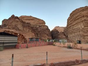 a building in front of a rock wall at happiness camp in Wadi Rum
