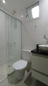 La salle de bains blanche est pourvue de toilettes et d'un lavabo. dans l'établissement Apartamento Alto Padrão próximo Agrishow, à Ribeirão Preto