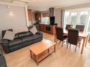 a living room with a leather couch and a table at Megstone in Beadnell