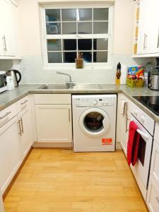 a kitchen with a washing machine and a sink at Ensuite Double Room in London