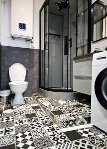 a bathroom with a black and white tile floor and a toilet at Le Canut Duviard - proche métro Croix-Rousse in Lyon