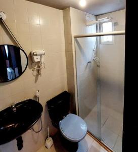 a bathroom with a toilet and a sink and a shower at Studio quartzo cinza - centro in Campos dos Goytacazes +6 photos