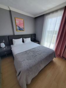 a bedroom with a large bed and a window at Budget Hotel Tourist Inn in Arnavutköy