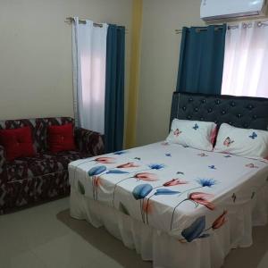 1 dormitorio con 1 cama y 1 sofá en Grande y acogedor apartamento cerca de la playa. en Azua de Compostela