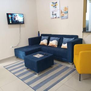 a living room with a blue couch and a yellow chair at Grande y acogedor apartamento cerca de la playa. in Azua de Compostela