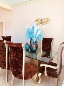 comedor con mesa de cristal y sillas en Grande y acogedor apartamento cerca de la playa. en Azua de Compostela