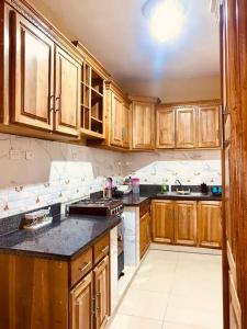 a kitchen with wooden cabinets and a stove top oven at Grande y acogedor apartamento cerca de la playa. in Azua de Compostela