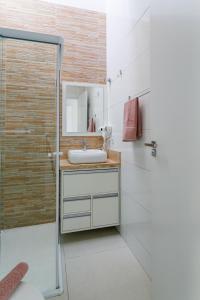 a bathroom with a sink and a shower at Curta Praia de Armação - Casa Coqueiro in Penha
