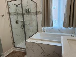 ein Badezimmer mit Dusche, Badewanne und Waschbecken in der Unterkunft Brand New South Sacramento Home in Sacramento + 32 Fotos