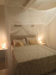 Bett in einem weißen Zimmer mit 2 Lampen in der Unterkunft OceanDream Beach House Apartment in Sal Rei