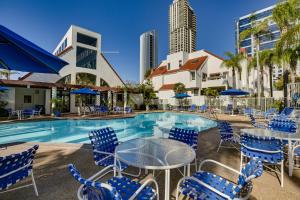 a swimming pool with blue chairs and a table with a table at Downtown San Diego Condo in Marina District! in San Diego