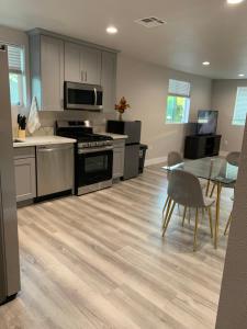 a kitchen with a stove and a table and a dining room at PRIVATE ROOM IN NEW APPARTMENT WITH FULL BATH in Los Angeles