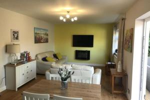 a living room with a couch and a table at Just Stay Wales - Marshmallow Cottage, Oxwich in Swansea