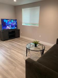 a living room with a couch and a table and a flat screen tv at PRIVATE ROOM IN NEW APPARTMENT WITH FULL BATH in Los Angeles