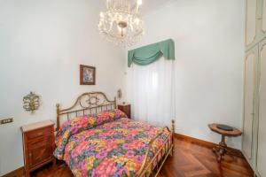 um quarto com uma cama e um lustre em Gemma Sea View em Nápoles