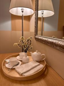 a table with a tea set on a table with a mirror at Relais Concorde in Grottammare