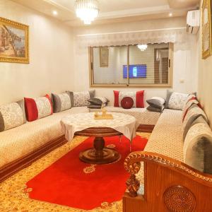 een woonkamer met een bank en een tafel bij Appartement Deux chambres résidence Privée in Marrakesh