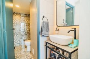Un baño con lavabo, inodoro y espejo. en Bocagrande Houstel Ctc Medium, en Cartagena de Indias