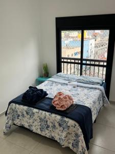 two beds in a room with a window at Vista Privilegiada 5 minutos da Basílica in Aparecida
