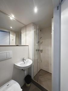 a bathroom with a shower and a toilet and a sink at FASTHOTEL ROISSY CDG SUD - Claye Souilly in Claye-Souilly