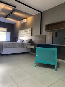 a bedroom with a bed and a blue chair at Casa em Piranhas AL - Alto Padrão in Piranhas