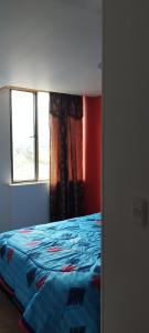 Schlafzimmer mit einem Bett und einem Fenster in der Unterkunft Ipiales Puerta de Oro Alborada in Ipiales