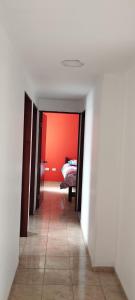 a hallway with a bed in a red room at Ipiales Puerta de Oro Alborada in Ipiales