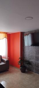 ein Wohnzimmer mit einem Sofa und einer Pflanze in der Unterkunft Ipiales Puerta de Oro Alborada in Ipiales