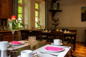 a dining room with tables and chairs with pink napkins at Landhaus Lastrup in Lastrup