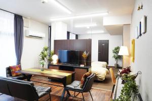 a living room with a table and a television at THE TORII - Vacation STAY 21195v in Kumamoto