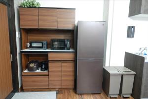 a kitchen with a refrigerator and a microwave at THE TORII - Vacation STAY 21195v in Kumamoto