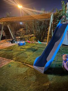 a playground with a blue slide in a park at luule in Al Ain