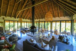 a large living room with couches and a fireplace at Barefoot Addo Elephant Lodge in Addo