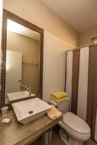 W łazience znajduje się umywalka, toaleta i lustro. w obiekcie Casa Luz De Luna-MANCORA w mieście Máncora
