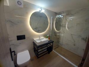a bathroom with a sink and a shower with a mirror at Konstantina in Ambelókipoi