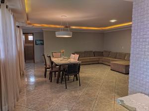 ein Wohnzimmer mit einem Tisch, Stühlen und einem Sofa in der Unterkunft Brasilia Vale Park Way in Brasilia