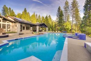 einen Pool mit blauem Wasser vor einem Haus in der Unterkunft Mansion, Pool, Game Room in Pollock Pines