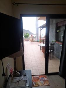 a room with a door open to a patio with a table at Winter Wonderland Villa in Tamaimo