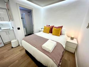 um quarto com uma cama grande com almofadas amarelas e vermelhas em APARTMENT IN THE HEART OF MADRID-PISO EN MALASAÑA em Madri
