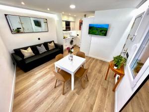 uma sala de estar com uma mesa e um sofá em APARTMENT IN THE HEART OF MADRID-PISO EN MALASAÑA em Madri