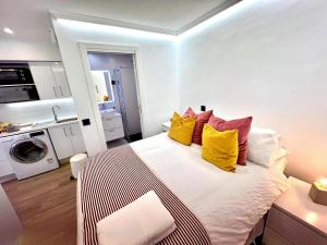 um quarto com uma cama com almofadas amarelas e vermelhas em APARTMENT IN THE HEART OF MADRID-PISO EN MALASAÑA em Madri