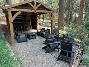 - un kiosque avec des chaises et un barbecue dans les bois dans l'établissement Cabin in the Trees - Hot Tub, à Pollock Pines