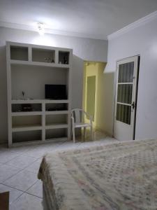 Schlafzimmer mit einem Bett, einem TV und einem Stuhl in der Unterkunft Brasilia Vale Park Way in Brasilia