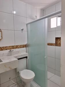 uma casa de banho com um WC e uma cabina de duche em vidro. em Girassol Pousada em Extremóz