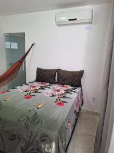 a bedroom with a bed with a floral bedspread at Girassol Pousada in Extremóz
